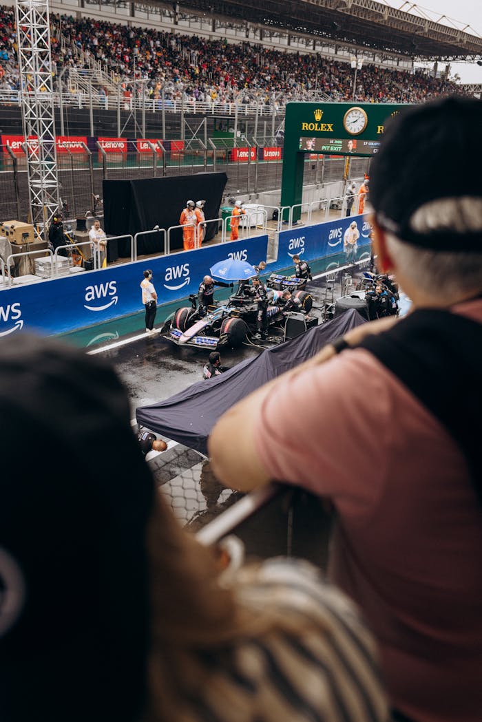 Dynamic pit stop scene during a Formula 1 race with an intense crowd and dedicated crew.